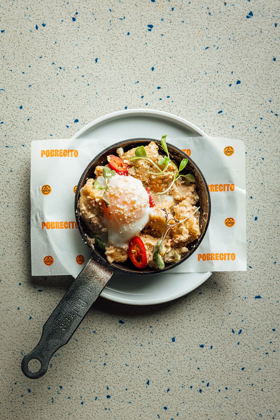 A rice bowl topped with an egg, served in a pan
