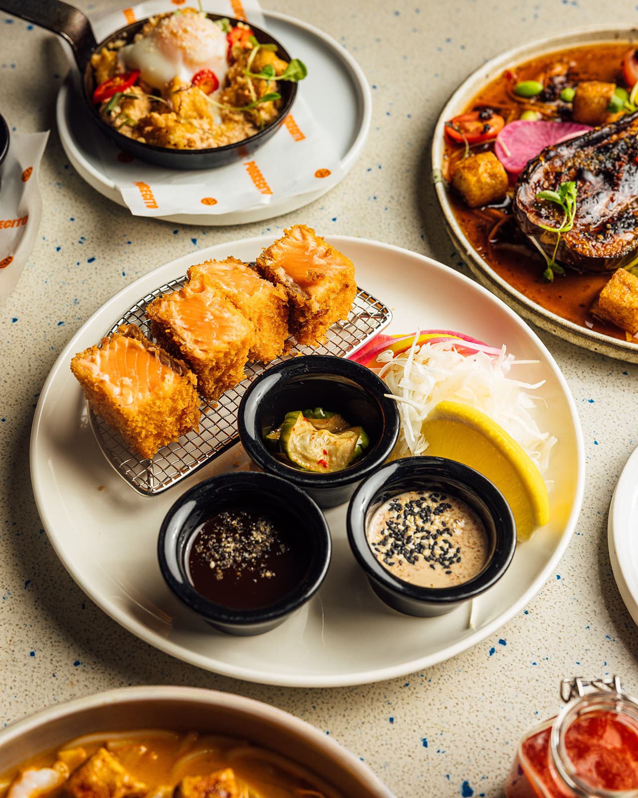 Salmon katsu, dipping sauces and evening plates on the table
